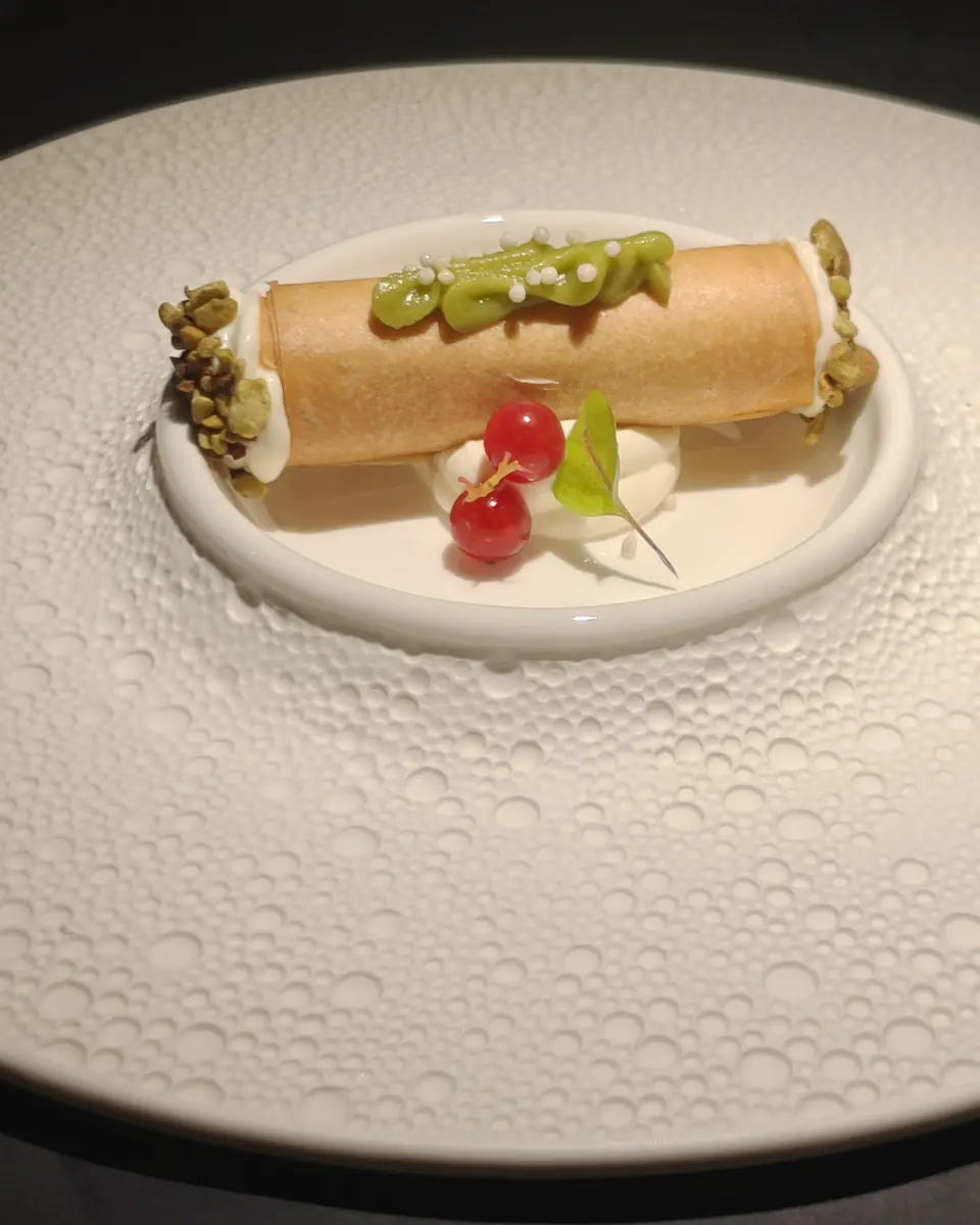 Roll in carta di soia con topping verde, su piatto bianco
