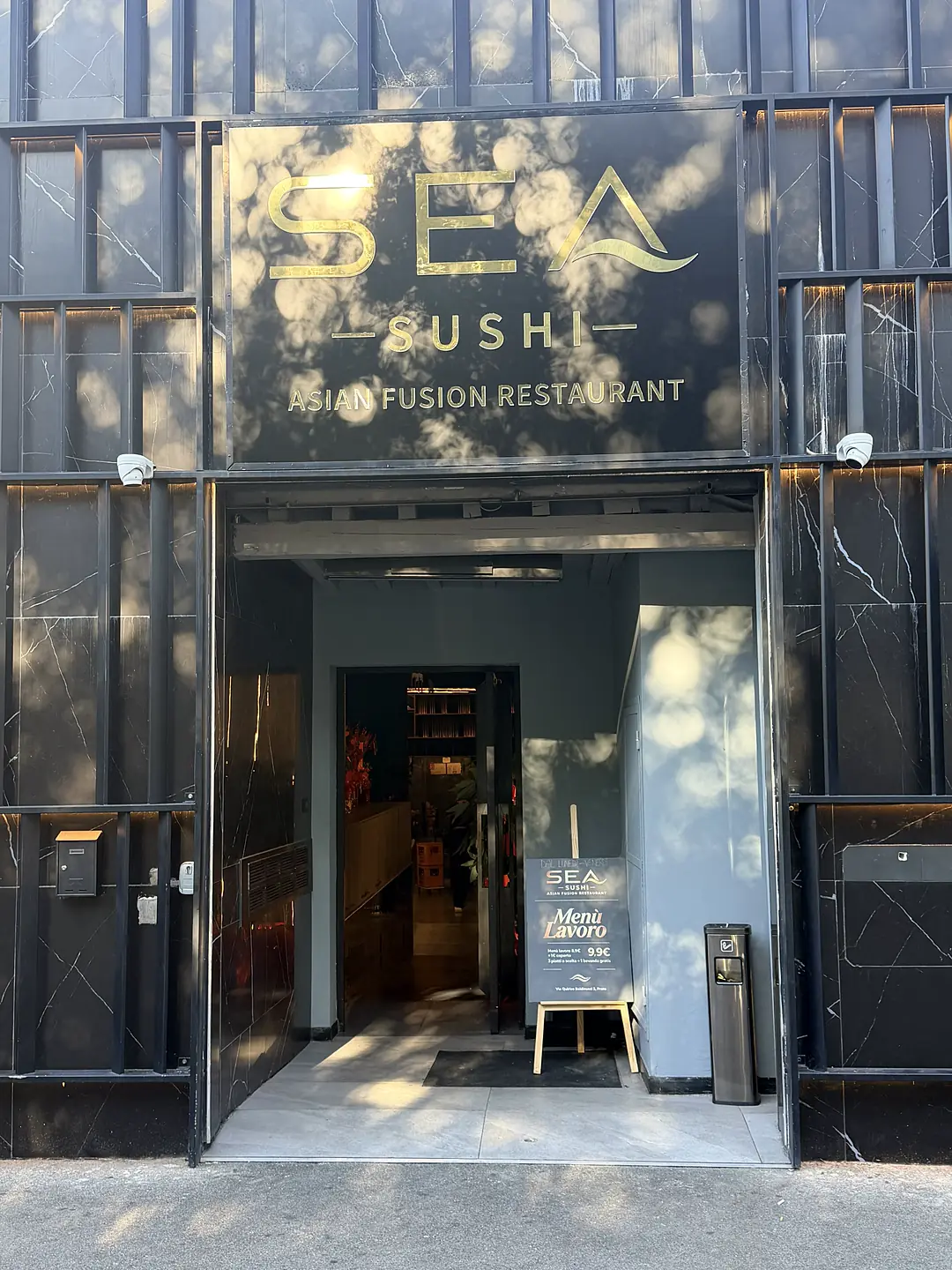 La facciata di giorno: l'insegna Sea Sushi sopra la porta d'ingresso e il cartello del Menù Lavoro