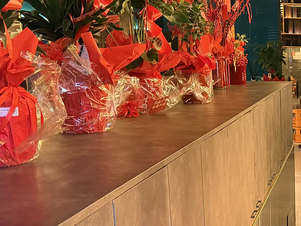 Composizioni di fiori rossi incartate sul lungo mobile dell'ingresso